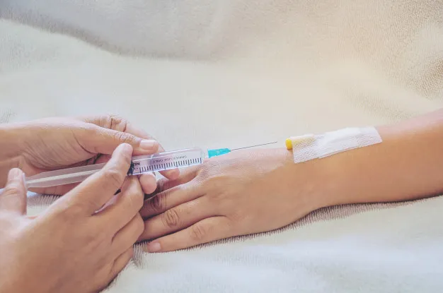 Medical professional administering IV Vitamin Therapy while comparing oral vitamin supplements at HMS Fat Freezing Dubai